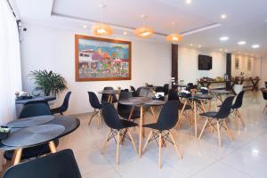 a restaurant with tables and chairs in a room at Pousada Ilha Branca Centro in Búzios +26 photos
