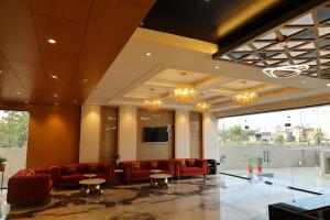 a lobby with red furniture and large windows at Manratan Resort in Narsinghgarh