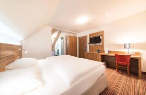 a hotel room with two beds and a desk at Béni golf club Clervaux hôtel & Restaurant in Eselborn
