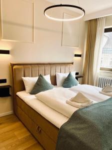 a bedroom with a large bed with a chandelier at Schwanstein Apartments Füssen ZENTRUM in Füssen