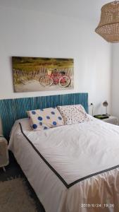 a bed in a bedroom with a painting on the wall at Luz del Mediterráneo in Moncófar