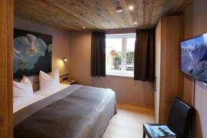 a hotel room with a bed and a window at Annika Apartments summer card included in Zell am See