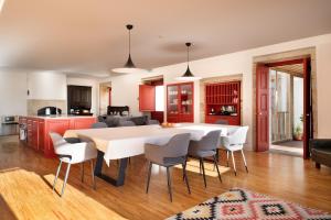 a kitchen and dining room with a white table and chairs at Casa Dr Ramiro Salgado - Douro Superior, Torre de Moncorvo in Torre de Moncorvo