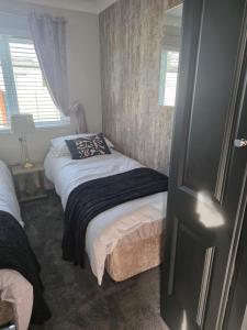 a small bedroom with two beds and a window at Dottys lodge in Felton