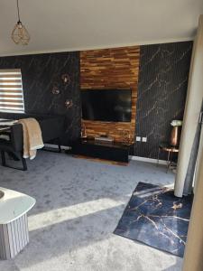 a living room with a flat screen tv on a wall at Dottys lodge in Felton