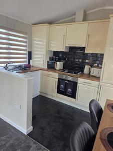 a kitchen with white cabinets and a stove top oven at Dottys lodge in Felton