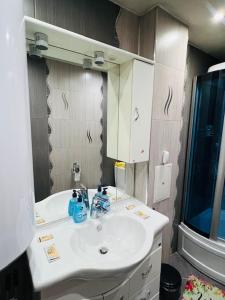 a bathroom with a white sink and a mirror at Апартамент за гости in Razlog