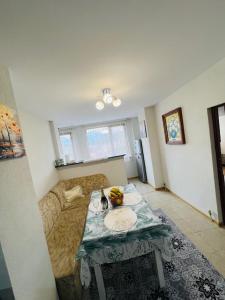 a living room with a table and a couch at Апартамент за гости in Razlog