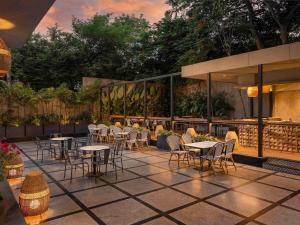 a group of tables and chairs on a patio at Grand Mercure Bangalore - An Accor Brand in Bangalore