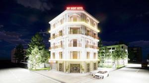 a white building with a red sign on top of it at Sky Night Hotel 2 in Việt Yên
