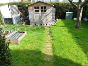a yard with a dog house in the grass at Le lagon zen in Ploufragan
