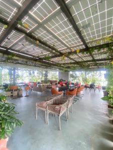 a large room with chairs and tables and plants at SRS Suites in Bangalore