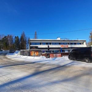 a van parked in front of a building in the snow at Hotel Sommarvind in Inkoo