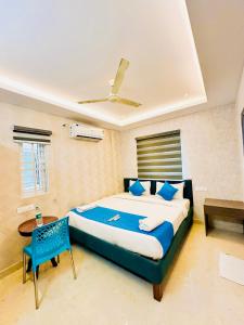 a bedroom with a large bed and a blue chair at SHR Comfort Near Reva Circle Yelahanka in Bangalore +23 photos