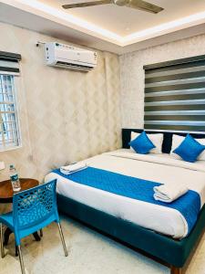 a bedroom with a large bed and a blue chair at SHR Comfort Near Reva Circle Yelahanka in Bangalore