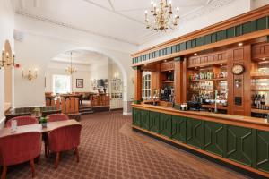a restaurant with a bar with tables and chairs at Coulsdon Manor Hotel and Golf Club in Croydon