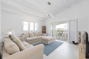 a white living room with a couch and a table at Villa Mare a fabulous hideaway in S'Algar