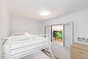 a white bedroom with a bunk bed and a window at Villa Mare a fabulous hideaway in S'Algar +36 photos