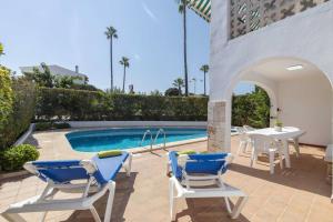 a patio with chairs and a table and a pool at Villa Mare a fabulous hideaway in S'Algar