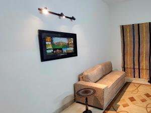 a living room with a couch and a picture on the wall at UrbanNook in Rawalpindi
