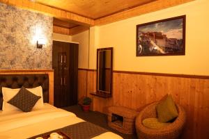 a hotel room with a bed and a chair at The Lume, Lachung in Lachung