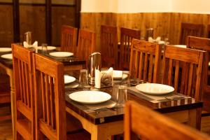a wooden table with white plates on top of it at The Lume, Lachung in Lachung
