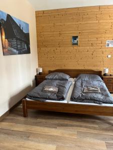 two beds in a bedroom with a wooden wall at Wellness hotel - Viktorka, herecký dům in Česká Skalice +40 photos