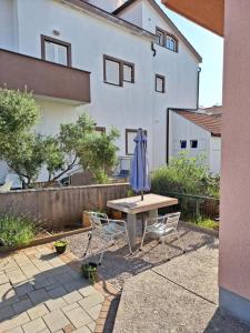 a table and two chairs and an umbrella on a patio at Apartmani Štefica in Razvala
