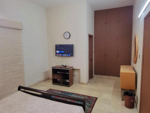 a room with a clock on the wall and a tv at UrbanNook in Rawalpindi