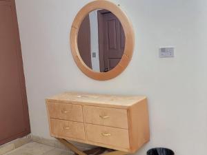 a wooden dresser and a mirror on a wall at UrbanNook in Rawalpindi +3 photos