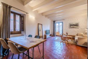 a living room with a wooden table and chairs at Flateli Santa Clara 21 in Girona