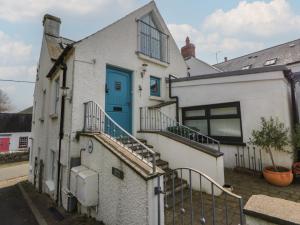a white house with a blue door and stairs at Awen Ingli in Newport