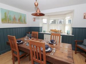 a dining room with a wooden table and chairs at Awen Ingli in Newport