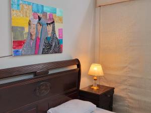 a bedroom with a bed and a painting on the wall at UrbanNook in Rawalpindi
