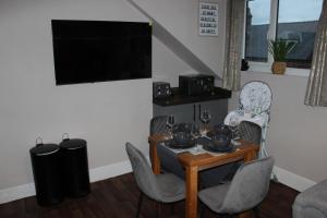a dining room with a table and chairs and a television at Blackburn Heights Sleeps 4 Family Apartment in Bridlington