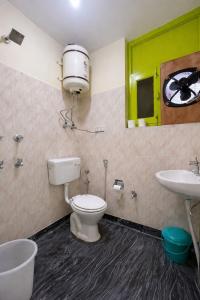 a bathroom with a toilet and a sink at Trippy Turtle Hostel in Manāli