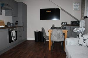 a living room with a table and chairs and a kitchen at Blackburn Heights Sleeps 4 Family Apartment in Bridlington