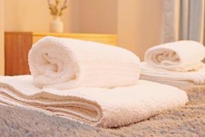 a stack of towels on a bed in a bathroom at Ashville Grange Scarborough Sleeps 10 Large Beautiful House in Scarborough +38 photos
