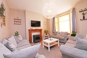 a living room with couches and a fireplace at Ashville Grange Scarborough Sleeps 10 Large Beautiful House in Scarborough