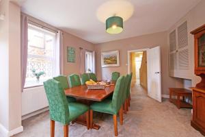 a dining room with a table and green chairs at Ashville Grange Scarborough Sleeps 10 Large Beautiful House in Scarborough
