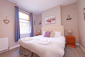a bedroom with a large bed with two towels on it at Ashville Grange Scarborough Sleeps 10 Large Beautiful House in Scarborough