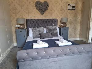 a bedroom with a large bed with two night stands at The Hampton Beautiful 3 Bedroom House with Conservatory & Garden in Scarborough