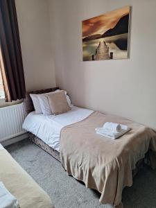 a bedroom with two beds and a picture on the wall at The Hampton Beautiful 3 Bedroom House with Conservatory & Garden in Scarborough