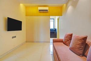 a living room with a couch and a television at FabHotel KV in Pen