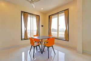 a dining room with orange chairs and a table at FabHotel KV in Pen