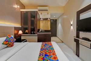 a bedroom with a large bed and a television at FabHotel KV in Pen