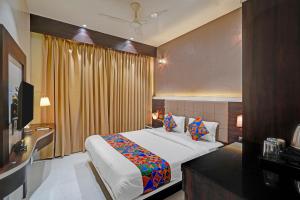 a bedroom with a large bed and a television at FabHotel KV in Pen