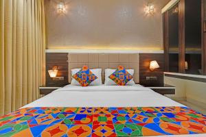 a bedroom with a large bed with a colorful comforter at FabHotel KV in Pen +19 photos