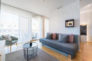 a living room with a blue couch and a chair at V7 Boutique Appartements in Freiburg im Breisgau