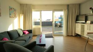 a living room with a couch and a table at Appartement Boodtlaan 4E in De Koog